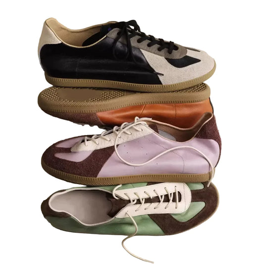 Stack of low-profile leather trainers in black, tan, lilac and green