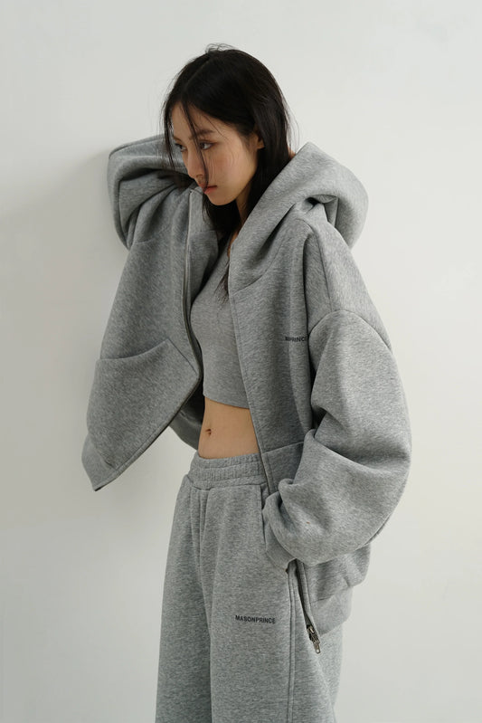 Woman in a matching oversized grey hoodie and sweatpants, a relaxed streetwear outfit