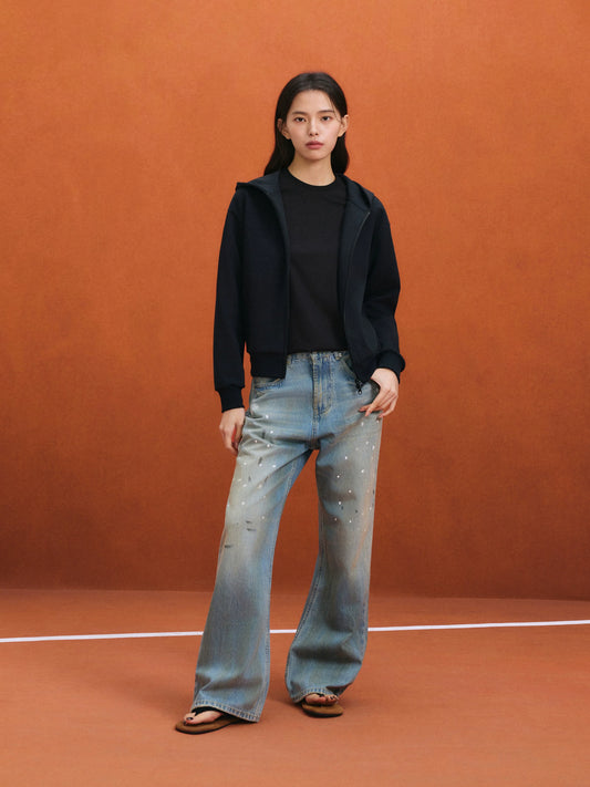 Model in light-wash straight-leg jeans and a black long-sleeve top