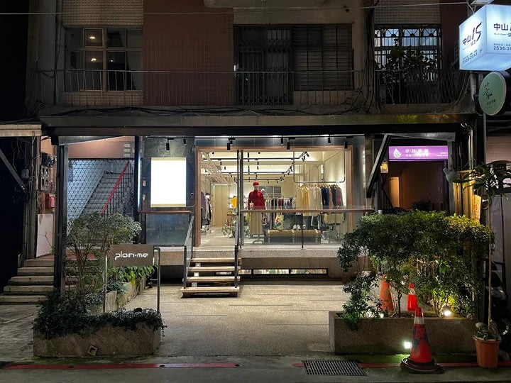 plain-me Taiwan storefront at night — lit select-shop windows