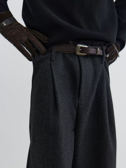 Black textured leather pin buckle belt worn with charcoal pleated trousers