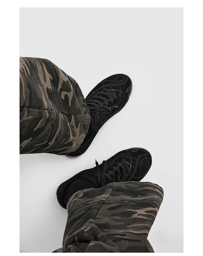 Black faux suede panelled sneakers worn with wide-leg trousers