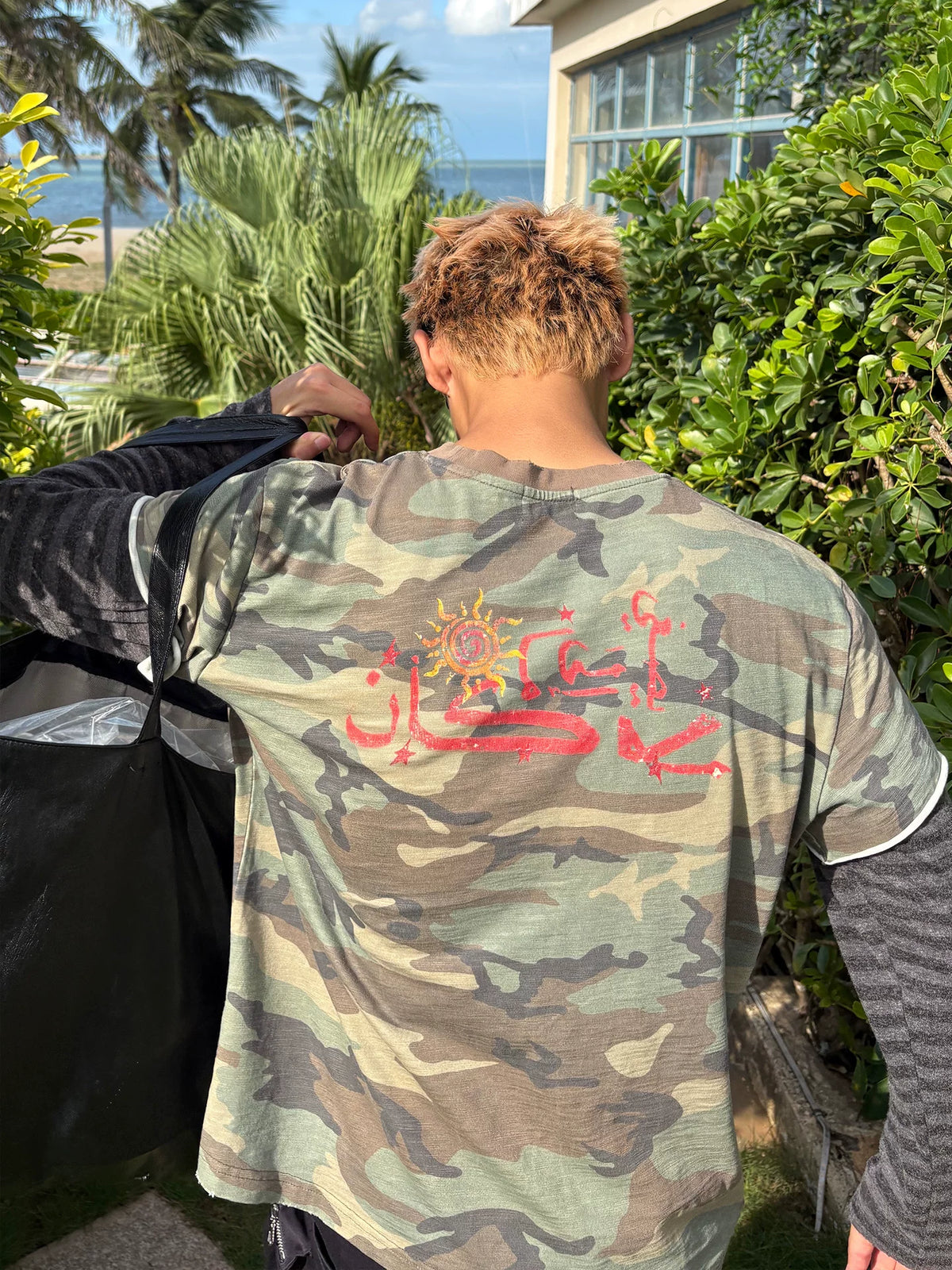 Back view of the camouflage shirt on model outdoors