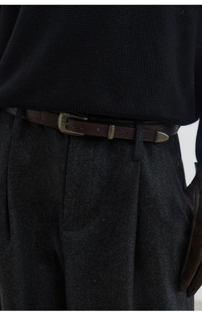 Black textured leather pin buckle belt, close-up at the waist