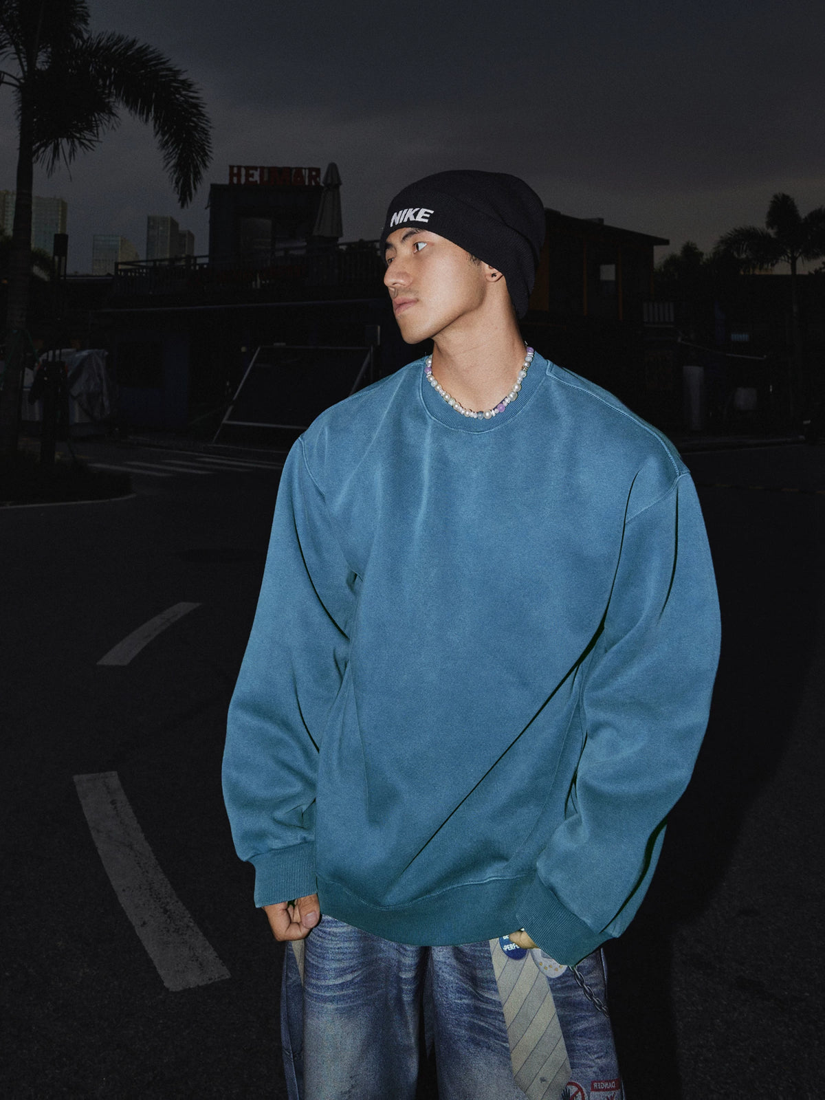 Blue crewneck sweatshirt, side view on model
