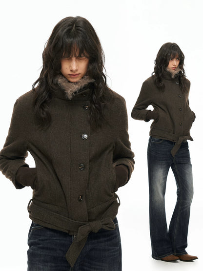 Dark belted jacket worn, front view