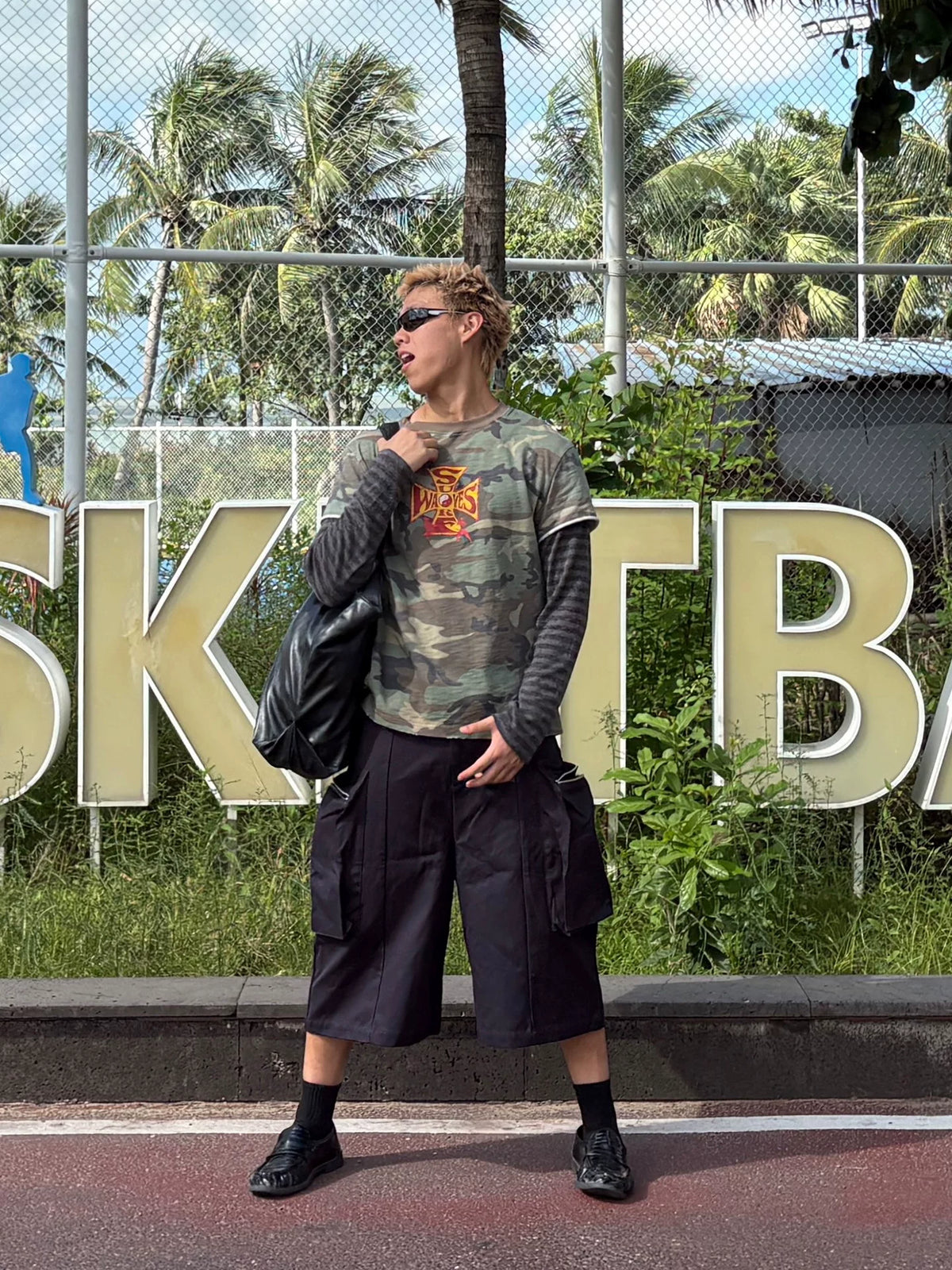 Model wearing the shirt with black shorts, front view