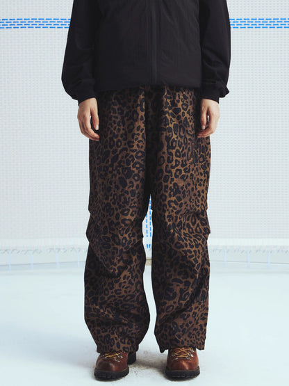 Brown leopard parachute pants worn with a black jacket, front view