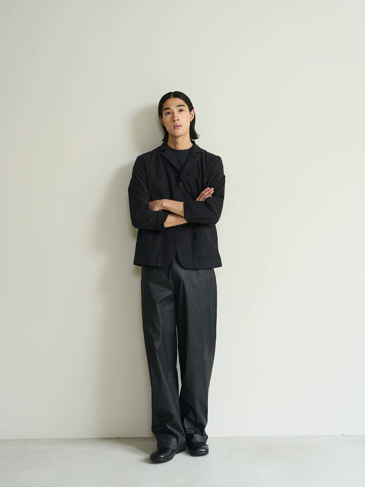 Black cotton utility blazer, full-length front view with arms crossed on model