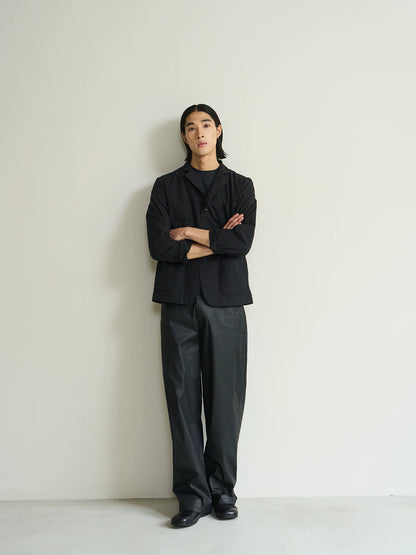 Black cotton utility blazer, full-length front view with arms crossed on model