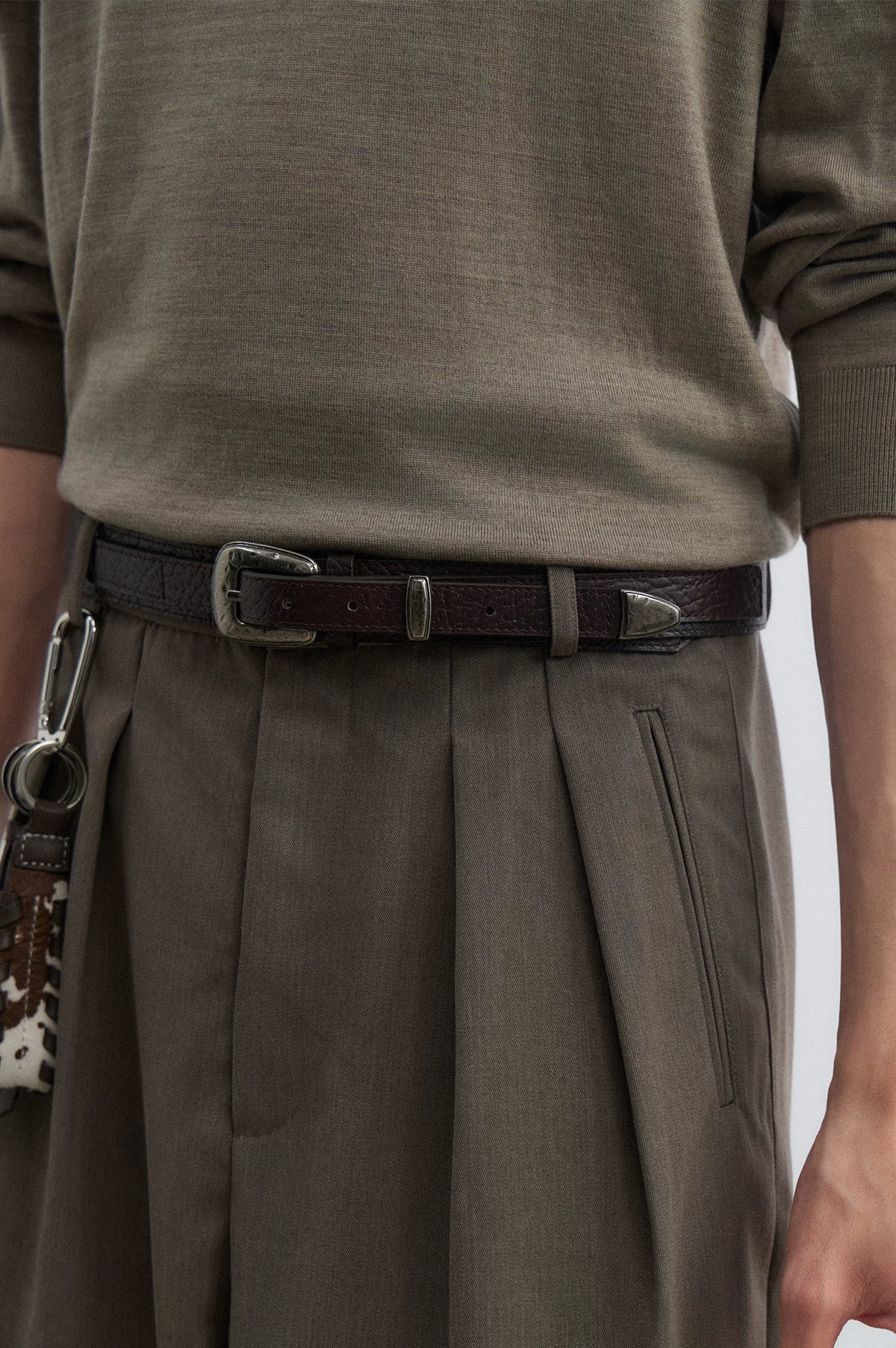 Brown textured leather pin buckle belt worn with trousers