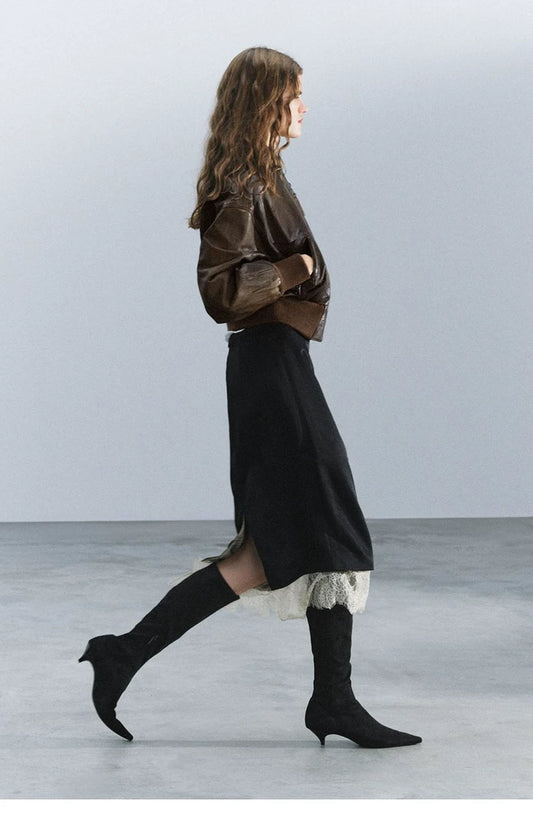 Black kitten-heel knee-high boots styled with a brown jacket and lace-trimmed skirt