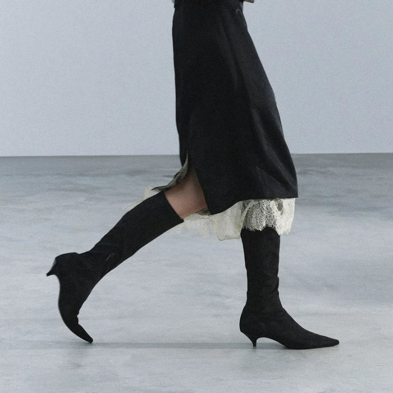 Black kitten-heel knee-high boots, walking outfit detail with a lace-trimmed skirt