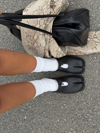 Black Unisex Tabi Toe Leather Cutout Knot Mule Sandals — black split-toe mules worn with white socks
