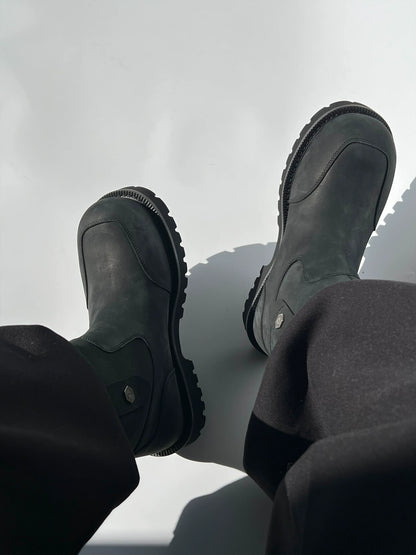 Dark suede winter boots worn with dark trousers, top view
