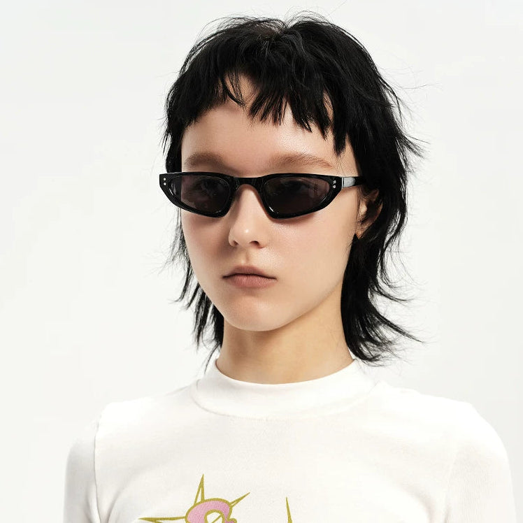 Petites lunettes de soleil triangulaires — coloris noir ; porté
