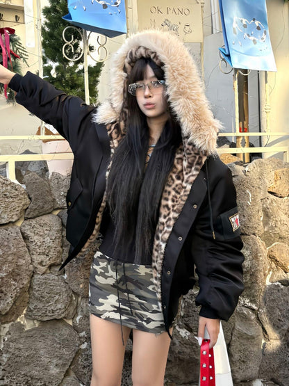 Black hooded pilot jacket worn outdoors with the hood up and one sleeve extended