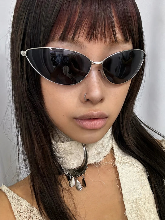 Model wearing silver-tone triangular cat-eye sunglasses with dark lenses.