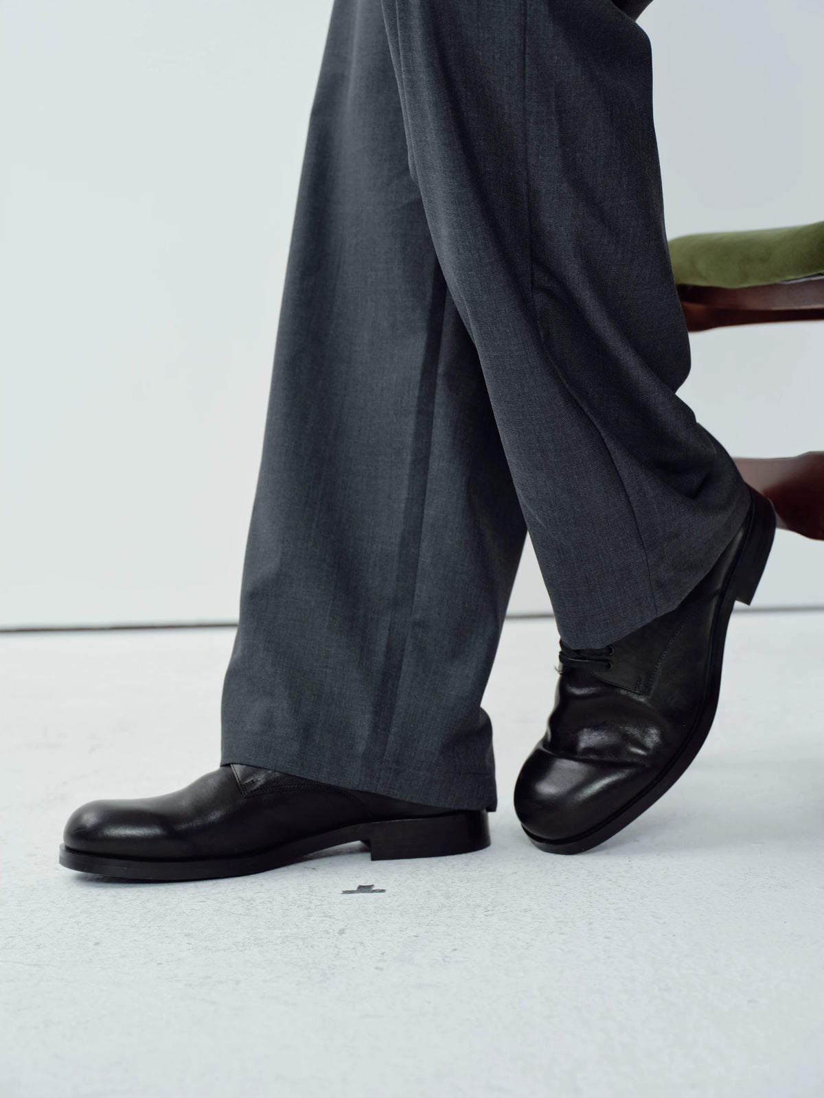 Side view of Wizard black square-toe Derby shoes worn with gray trousers