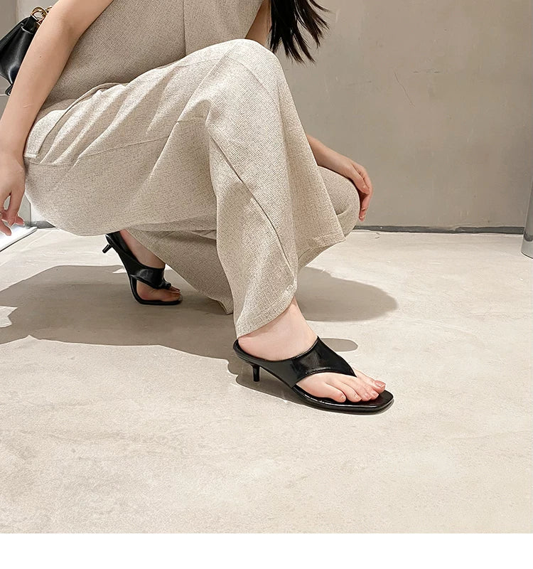 Women's Square Toe Mid-Heel Thong Slide Sandals — model wearing black thong mules, crouching